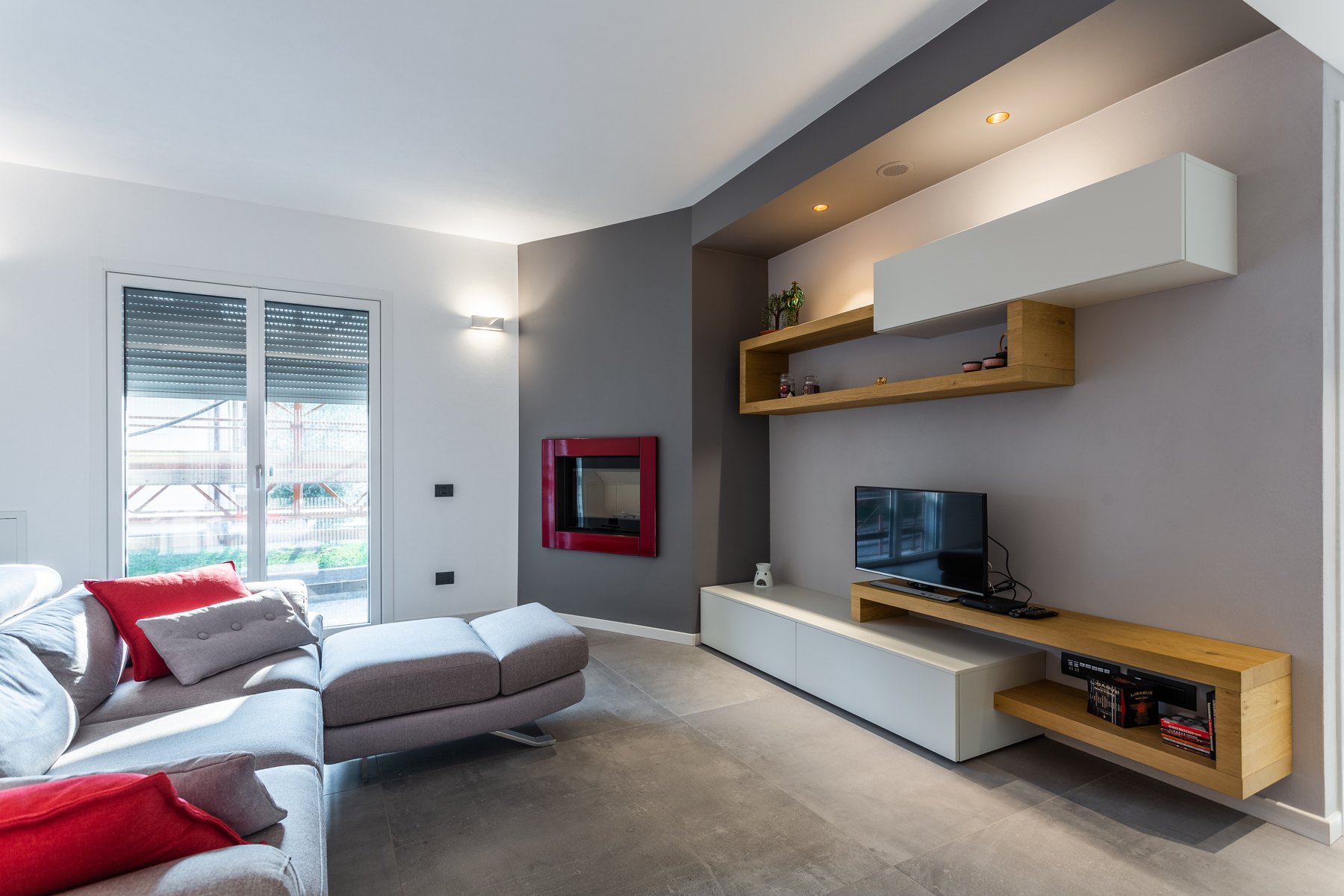 Soggiorno con parete TV, mensole in legno e caminetto — Giovanni Conti Interior Design